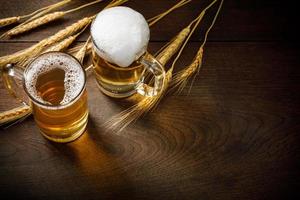 vasos de cerveza ligera con trigo en la mesa de madera, copie el espacio para su texto foto