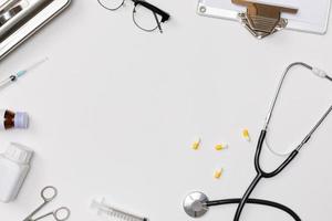 Creative flatlay of doctor medical equipment white table with stethoscope, medical documents, thermometer, syringe and pills, Health care concept, Top view with copy space, Isolated on white photo