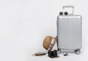 equipaje de viaje con pasaporte, cámara, sombrero, juguete de avión y teléfono inteligente aislado en fondo blanco con espacio de copia, fondo de concepto de viaje foto