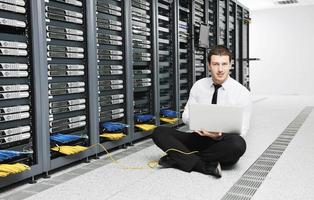 businessman with laptop in network server room photo