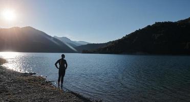 triathlon athlete starting swimming training on lake photo