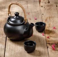 Cup of hot tea with steaming jugs on the wooden table background with copyspace for your text, Chinese style photo