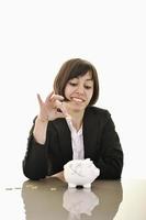 business woman putting coins money in piggy bank photo