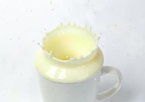 salpicaduras de leche de la taza foto