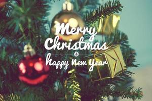 Christmas tree with gifts on green background on blurred, vintage color style and text - Merry Christmas and Happy New Year photo