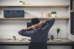 Young male freelancer with computer in room area, Man working at the desk, Freelance artist creative photo