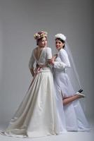 Portrait of two beautiful young bride in wedding dresses photo