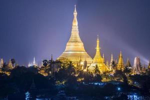 vista nocturna de la pagoda de shwedagon, el corazón del municipio de yangon de myanmar. esta pagoda se cree que contiene reliquias de los cuatro budas anteriores. foto