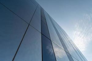 Modern mirror wall decoration of business center, copy space. Bottom view to texture of exterior design. Contemporary pattern of buildings. Looking up. photo