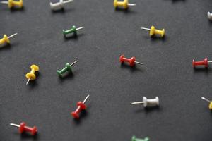 Multicolored plastic power buttons on a black background. Beautiful close-up stationery buttons.