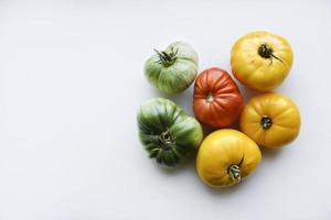 Yellow green and red tomatoes on a white background. Beautiful multicolored tomatoes close-up. photo