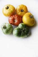 Yellow green and red tomatoes on a white background. Beautiful multicolored tomatoes close-up. photo