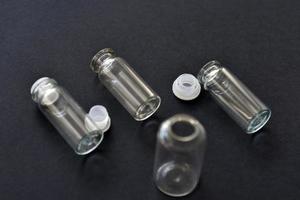 Glass empty bottles on a black background close-up. Pharmacy bottles in the afternoon in a group. photo