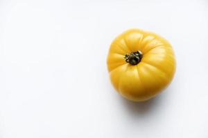 Beautiful large tomato close-up on a white background. Isolated shiny yellow green and red tomato. photo