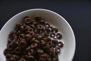 Delicious chocolate corn rings in milk in a cup. Delicious breakfast of cornflakes and milk. photo