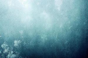 A computer generated illustration of a grunge wall surface texture background in blue, teal, turquoise colour. A.I. generated art. photo