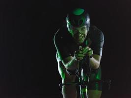 atleta de triatlón montando bicicleta por la noche foto