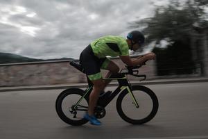atleta de triatlón montando en bicicleta en el entrenamiento matutino foto