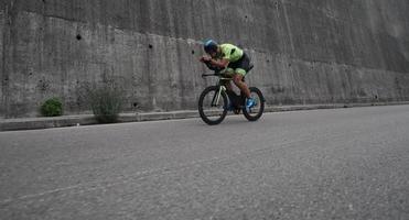 atleta de triatlón montando en bicicleta en el entrenamiento matutino foto