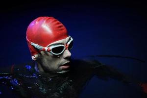 nadador triatleta auténtico que tiene un descanso durante el entrenamiento duro en la noche foto