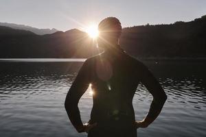 atleta de triatlón comenzando a nadar en el lago foto