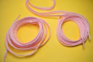 pink shoelaces on a yellow background photo