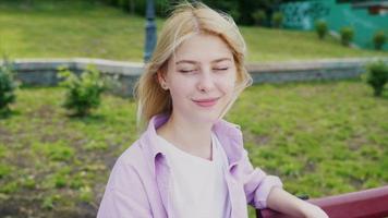 Girl sitting at park bench video