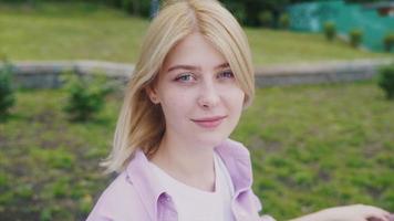 Girl sitting at park bench video