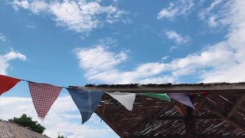 bandeira de flâmula triangular multicolor acena ao vento em um dia ensolarado video