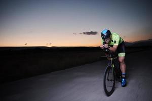 triathlon athlete riding bike fast  at night photo