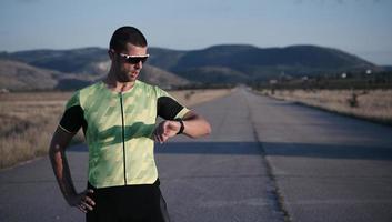 atleta de triatlón descansando y configurando el reloj inteligente foto