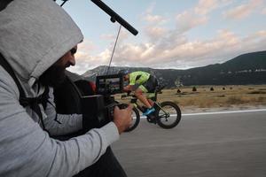 cinematographer taking action shot of triathlon bike athlete photo