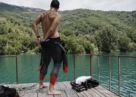 atleta de triatlón preparándose para el entrenamiento de natación en el lago foto