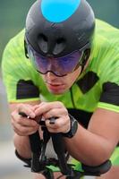 atleta de triatlón montando en bicicleta en el entrenamiento matutino foto