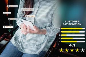 Adult woman using a smartphone in give rating to service experience on application. Online customer review satisfaction feedback survey. photo