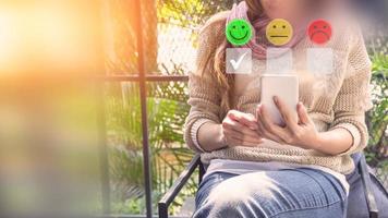 Adult woman using a smartphone in give rating to service experience on application. Online customer review satisfaction feedback survey. photo