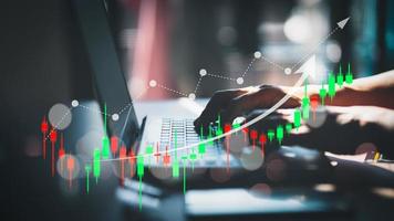 Financial technology and investment ideas with stock markets and mutual funds. Man analyzing financial data with graph trading from laptop at home. photo