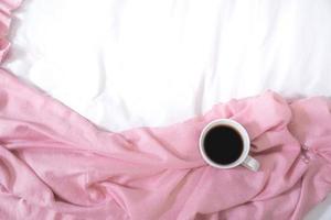 Christmas composition. Cup of coffee, scarf on pink background. Christmas, winter concept. Flat lay, top view, copy space photo