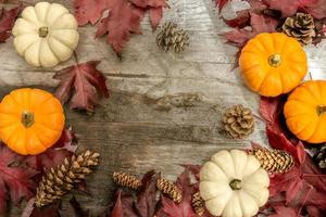 Festive autumn decor from pumpkins, pine and leaves on a  wooden background. Concept of Thanksgiving day or Halloween. Flat lay autumn composition with copy space. photo