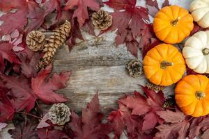 decoración festiva de otoño de calabazas, pinos y hojas sobre un fondo de madera. concepto de día de acción de gracias o halloween. composición plana de otoño con espacio de copia. foto