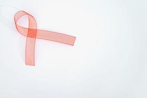 Closeup red ribbon awareness on White background for World Aids day campaign. Healthcare and medicine concept. photo