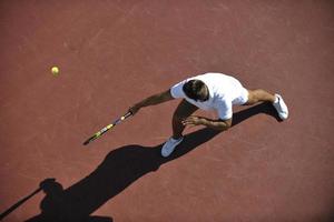 joven jugar al tenis al aire libre foto