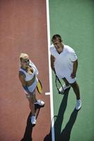 happy young couple play tennis game outdoor photo