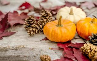 Festive autumn decor from pumpkins, pine and leaves on a  wooden background. Concept of Thanksgiving day or Halloween. Flat lay autumn composition with copy space. photo