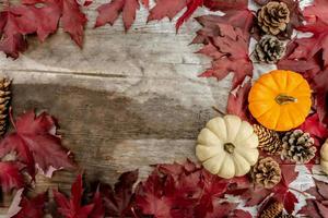 Festive autumn decor from pumpkins, pine and leaves on a  wooden background. Concept of Thanksgiving day or Halloween. Flat lay autumn composition with copy space. photo