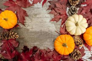 decoración festiva de otoño de calabazas, pinos y hojas sobre un fondo de madera. concepto de día de acción de gracias o halloween. composición plana de otoño con espacio de copia. foto