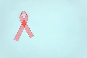 Closeup red ribbon awareness on White background for World Aids day campaign. Healthcare and medicine concept. photo