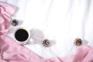 Christmas composition. Cup of coffee, scarf on pink background. Christmas, winter concept. Flat lay, top view, copy space photo