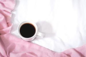 Christmas composition. Cup of coffee, scarf on pink background. Christmas, winter concept. Flat lay, top view, copy space photo