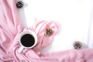 Christmas composition. Cup of coffee, scarf on pink background. Christmas, winter concept. Flat lay, top view, copy space photo